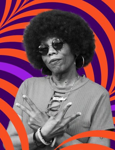 DJ Lady Love makes two peace signs with her arms crossed in front