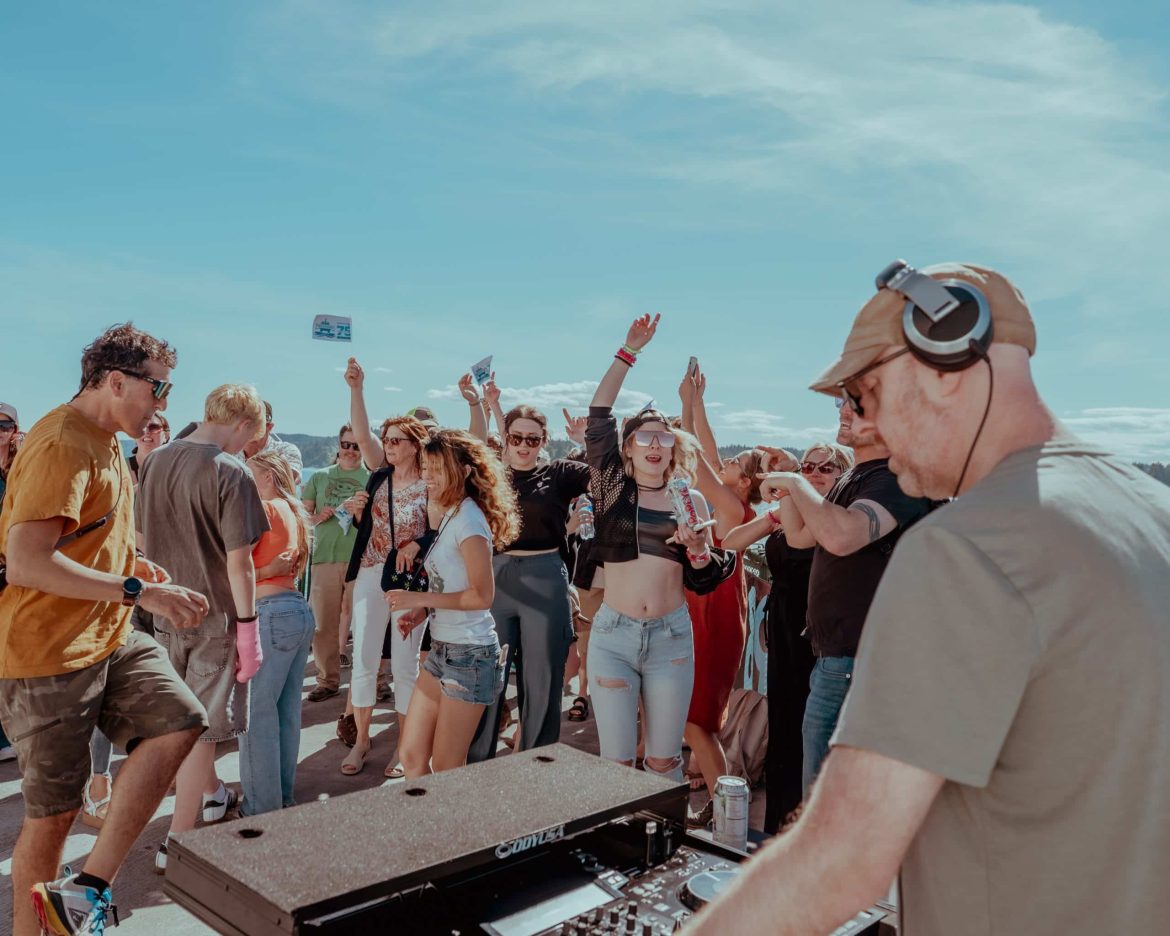 Johnny Monsoon DJing on a ferry to dancing crowd