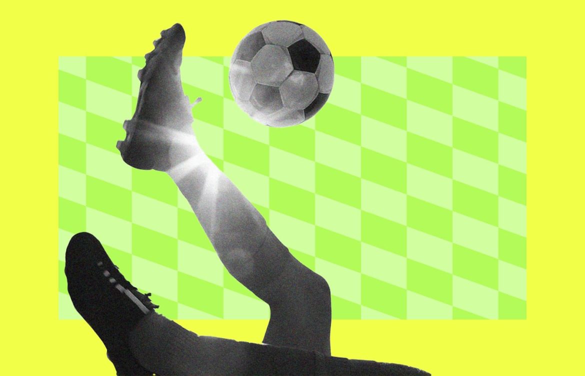 A person kicks a soccer ball in mid-air against a background with a yellow and green checkered pattern.